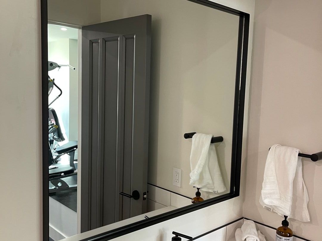 Black-framed mirror above a bathroom vanity