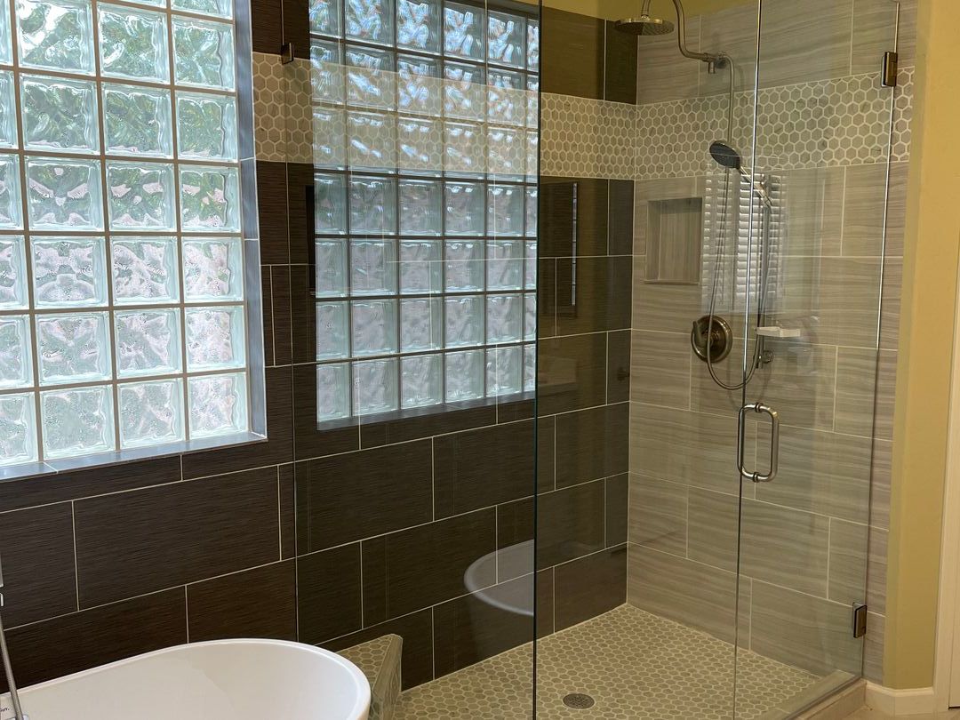 Frameless glass shower with an existing glass block window retained in the wall