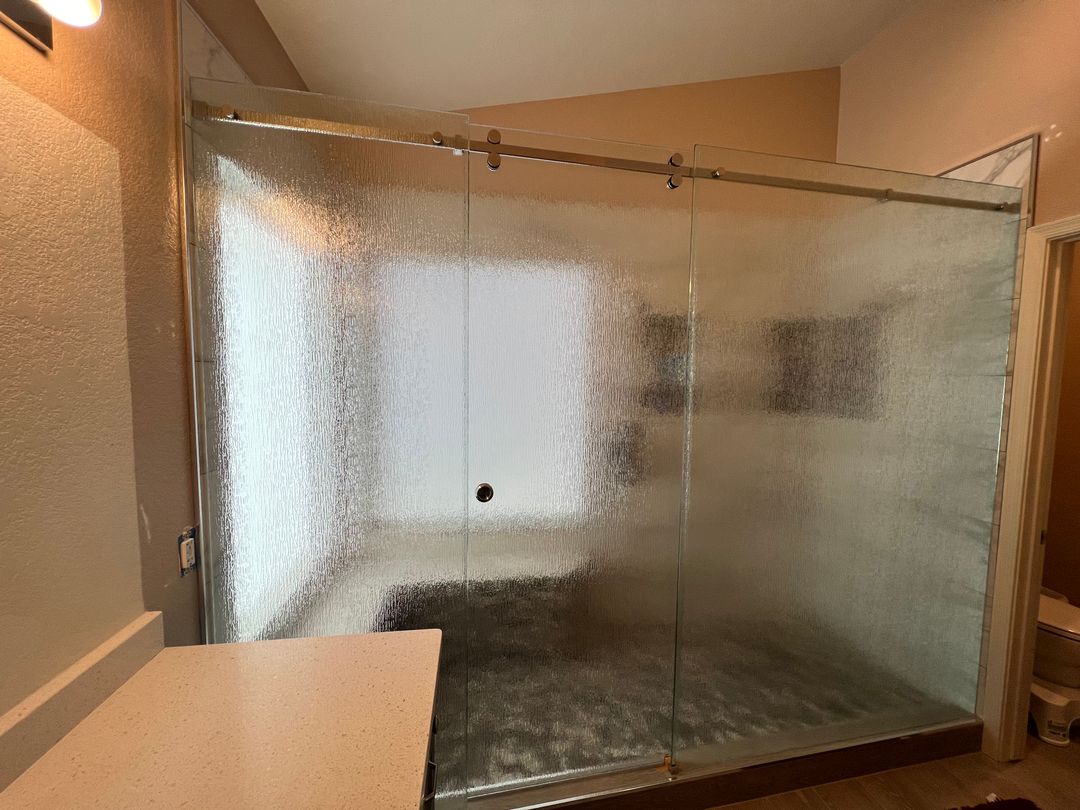 Shower enclosure in Gilbert with textured rain glass on a barn door slider track