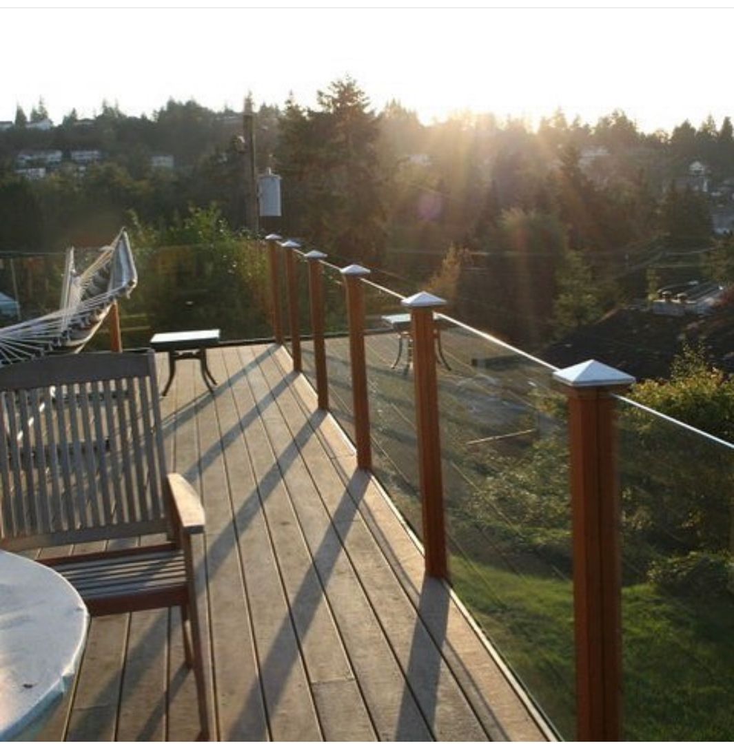 Glass deck railing with wood posts at sunset