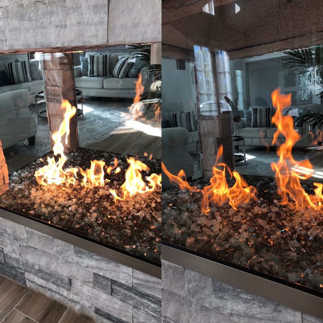 Frameless glass fireplace surround with flames over a glass fire bed