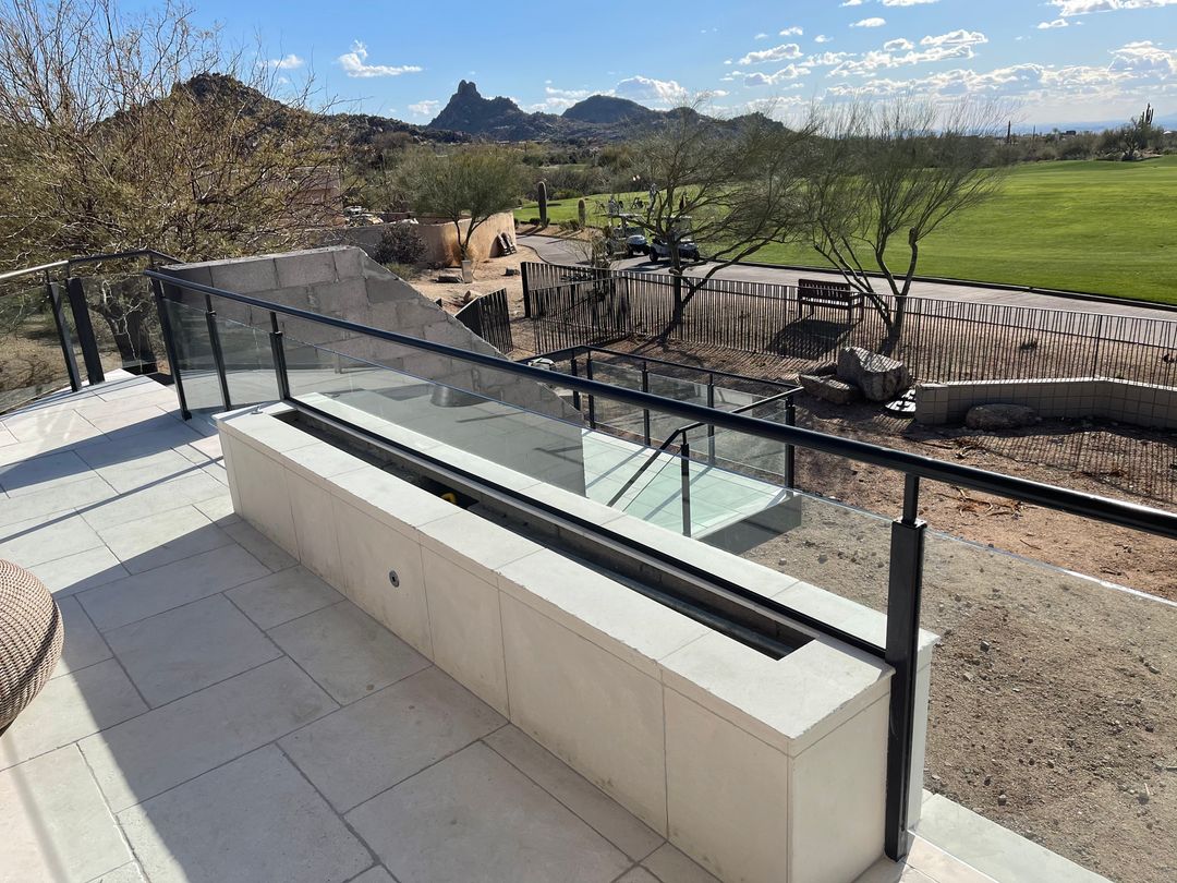 Glass balcony railing overlooking desert scenery at a Scottsdale property